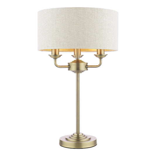 Classic antique brass table lamp with natural shade on a white background.