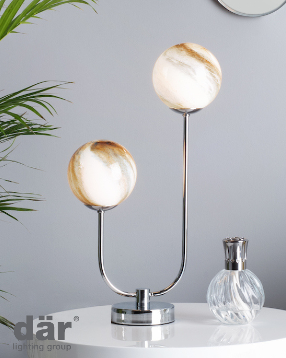 Two dar lighting table lamps with marble-like glass shades on a surface with a plant and decorative item in the background.