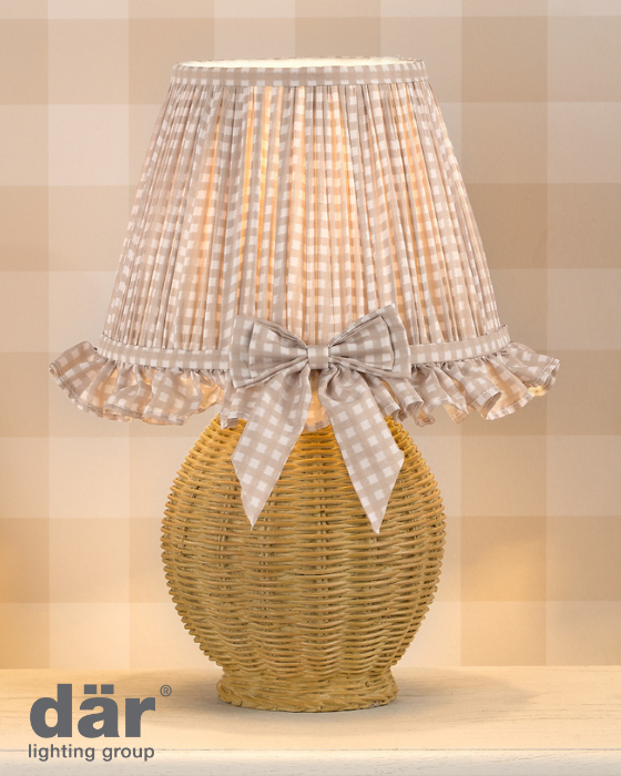 Wicker table lamp with checkered lampshade and bow on a neutral background