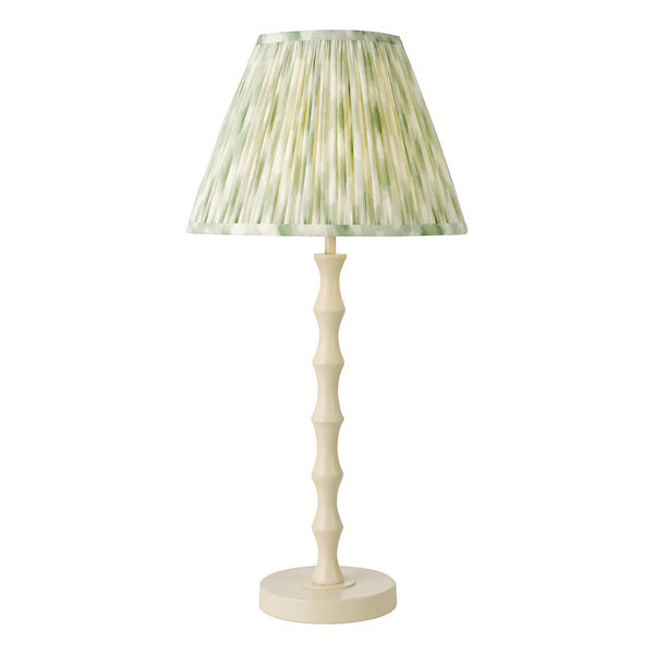 Cream wooden table lamp with a green pleated shade on a white background