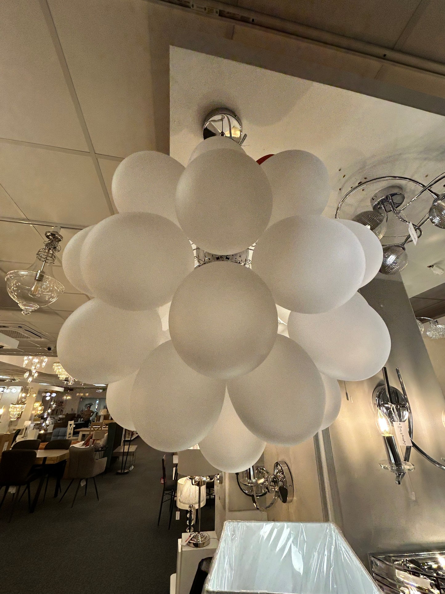 Dar Lighting chandelier with multiple round glass shades in a showroom setting