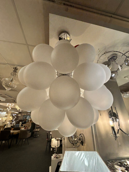 Dar Lighting chandelier with multiple round glass shades in a showroom setting