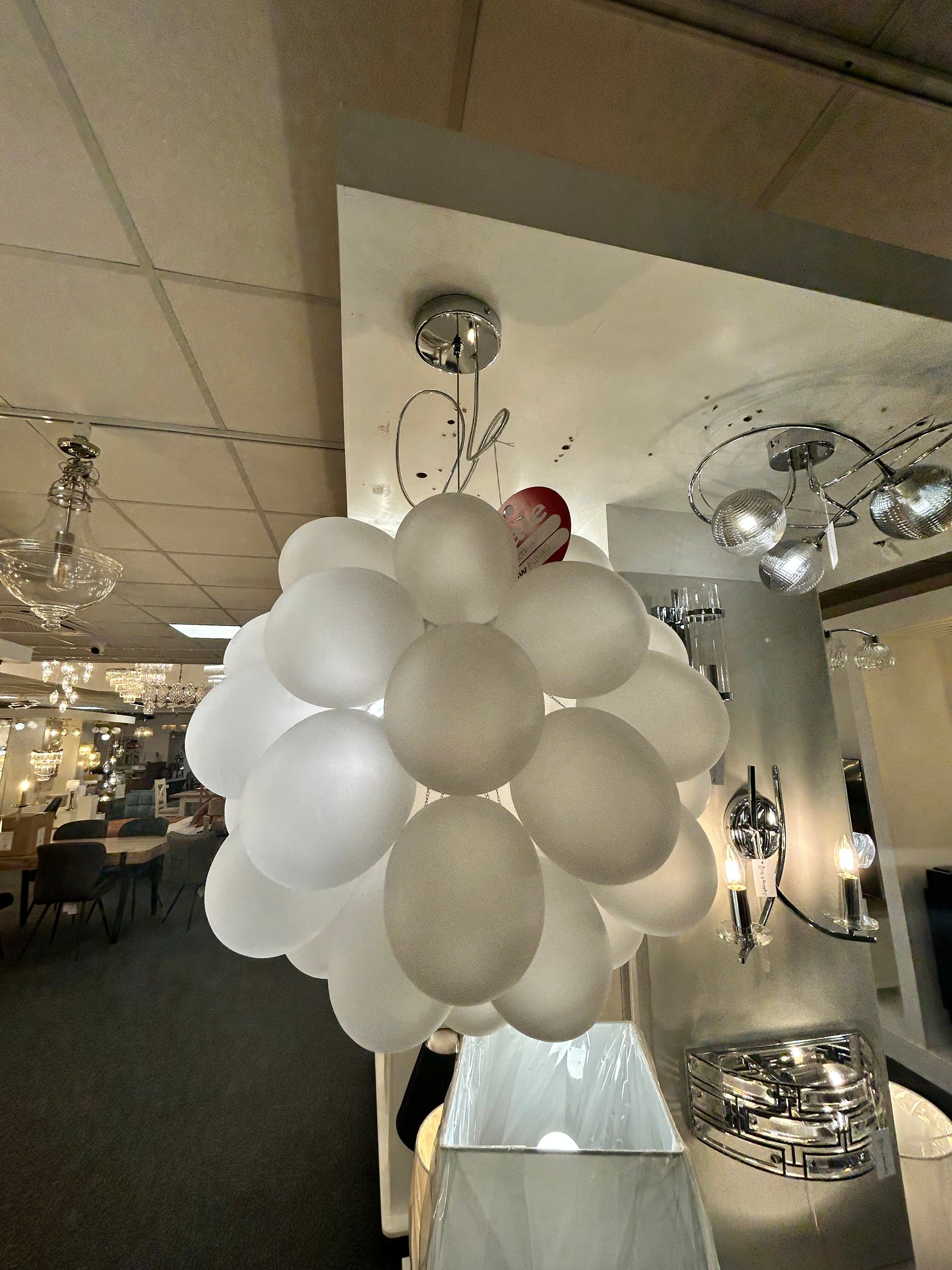 Dar Lighting modern chandelier with multiple spherical lights in a room setting.