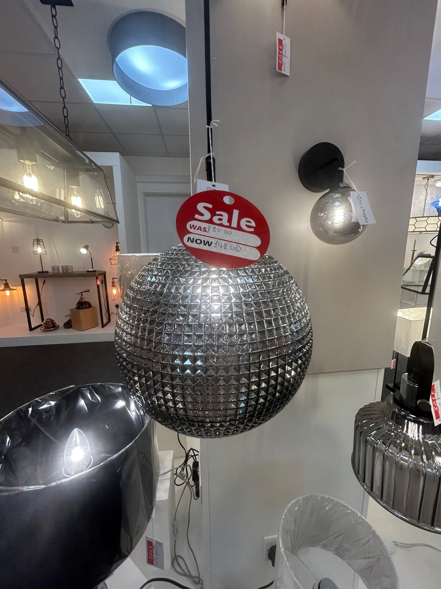 Dar Lighting crystal disco ball with a 'Sale' sign on a white surface in a store setting.