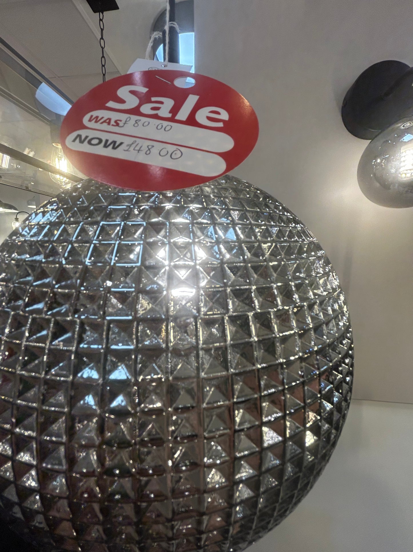 Dar Lighting silver disco ball with a 'Sale' sign in the background