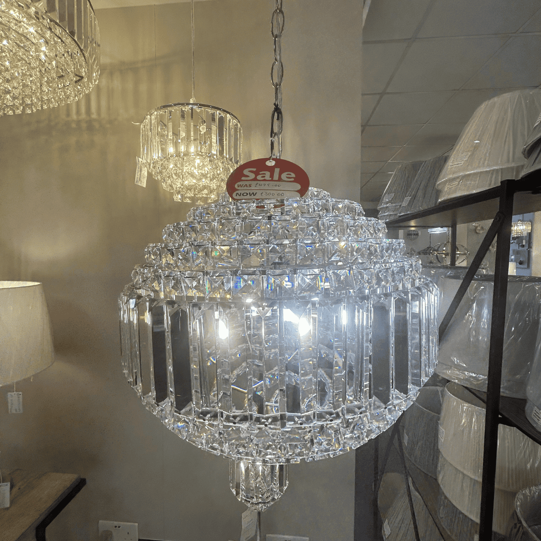 Laura Ashley crystal chandelier with a 'Sale' tag in a store setting