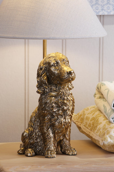 Gold dog-shaped lamp on a wooden surface with a neutral background