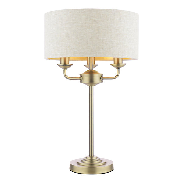 Classic antique brass table lamp with natural shade on a white background.