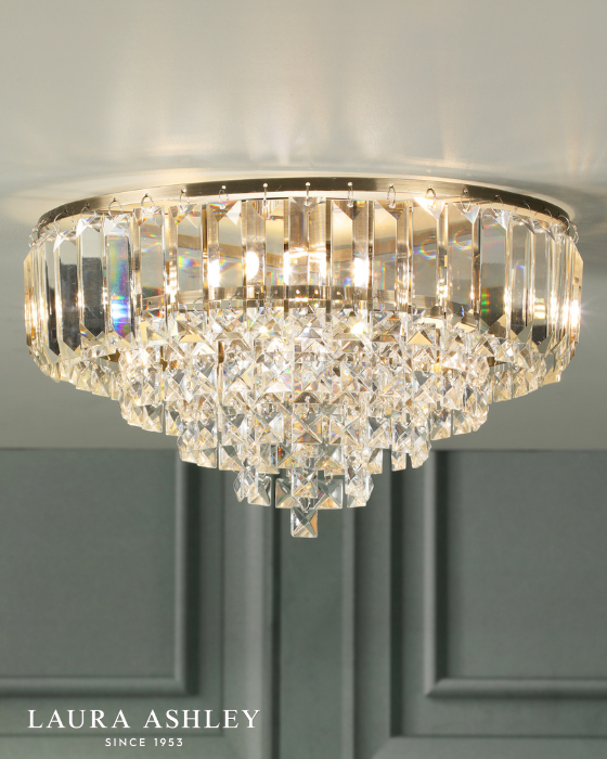 Crystal and antique brass flush ceiling light with 'Laura Ashley' branding on a white ceiling with grey wall background.